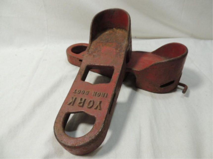 York Barbell Company iron boots, designed to allow weightlifters to attach barbell plates to either side of the boots.