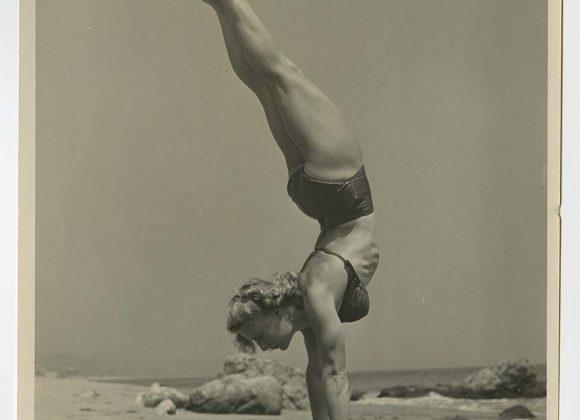 Bodybuilder Pudgy Stockton doing a handstand, in a bikini, on the beach, from the Pudgy and Les Stockton Collection.