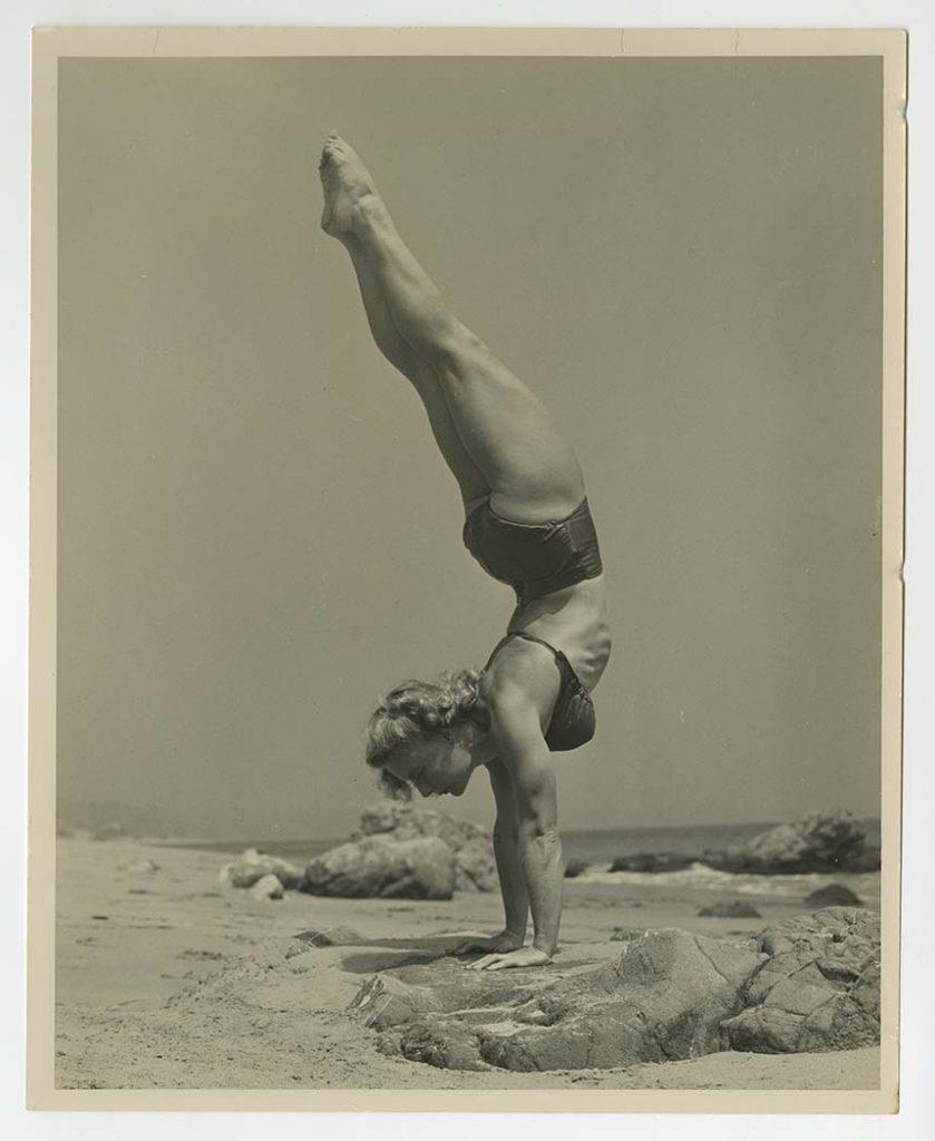 Bodybuilder Pudgy Stockton doing a handstand, in a bikini, on the beach, from the Pudgy and Les Stockton Collection.
