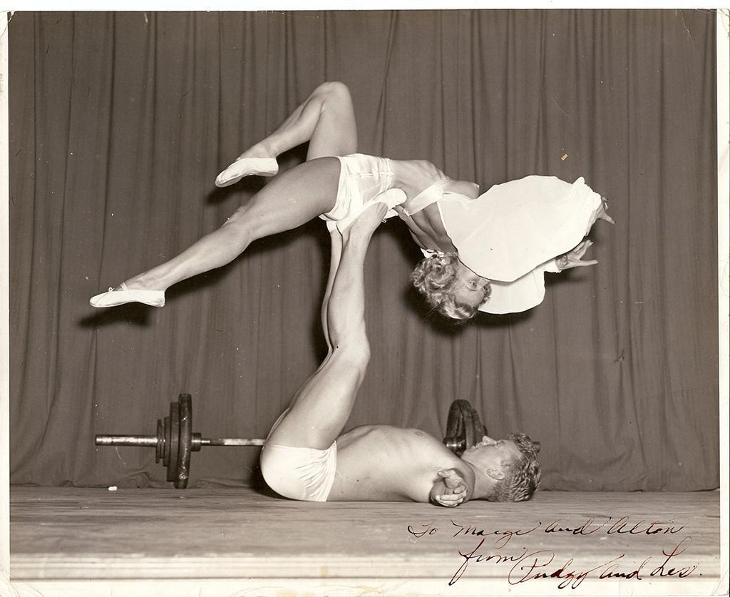 An autographed photograph of bodybuilder Les Stockton, in a swimsuit, balancing bodybuilder Pudgy Stockton in a backbend, in a bikini, on his feet, from the Pudgy and Les Stockton Collection.