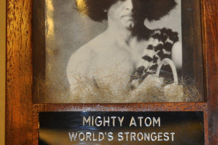 Trophy including a photograph and a lock of hair, from strongman Mighty Atom (Joseph L. Greenstein), commemorating him as having the world's strongest hair, compliments of Slim the Hammerman.