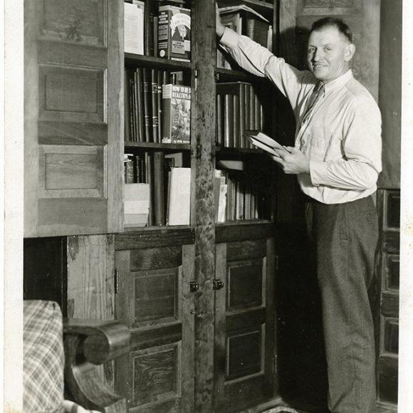 Strongman Ottley Coulter, with some of the books in his physical culture library, from the Ottley Coulter Collection.