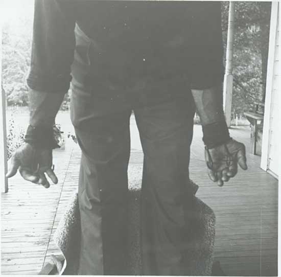 Weightlifter Bob Peoples, with the weightlifting hooks Peoples invented to help people do barbell curls, likely from the Peary and Mabel Rader Collection.