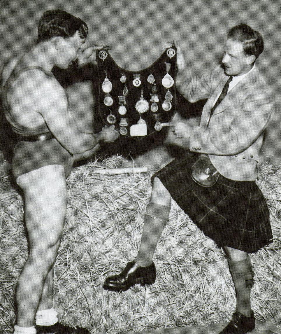 Gordon Dinnie and David Webster hold up one of Dinnie's breast plates with medals.