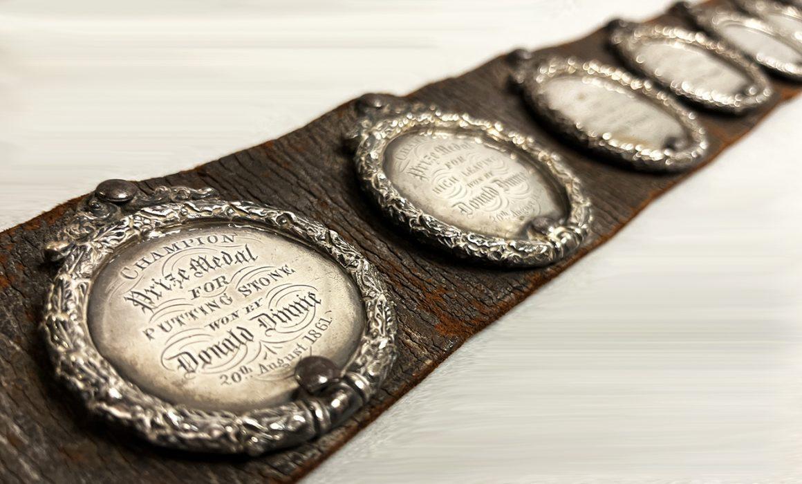 Close up view of Donald Dinnie's leather belt with silver medals.