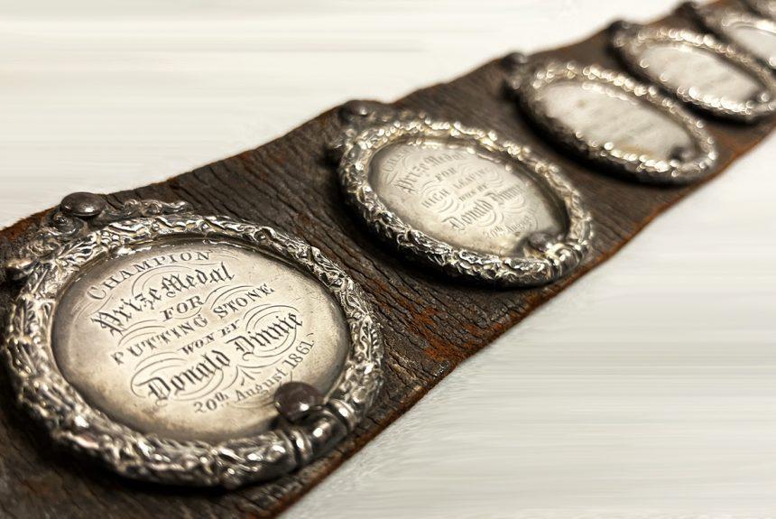 Close up view of Donald Dinnie's leather belt with silver medals.