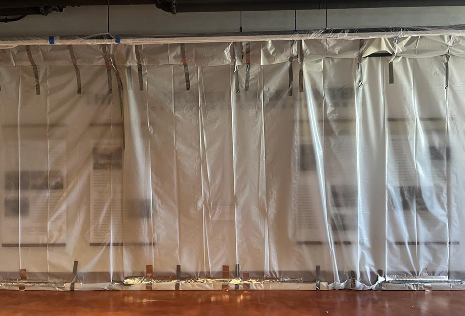 This is a photo of the wall across from our elevators which normally featured a portrait of Lutcher Stark and infographics about his life and work; the portrait has been rehoused in our archive and the entire wall is covered in thick plastic for protection from floor construction.