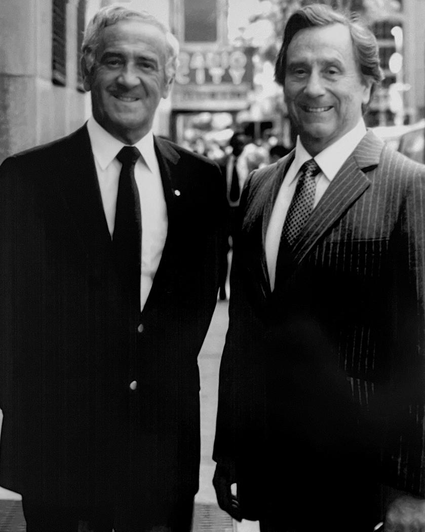 Photo of Joe Weider with his younger brother and long-time business partner Ben Weider. Both men are wearing business suits and ties.
