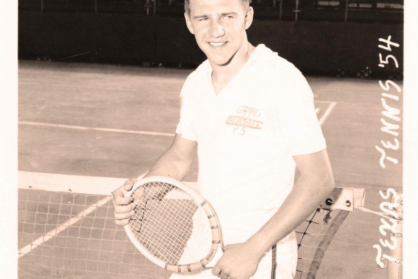 A black and white photo from 1954 of UT men's tennis player Dave Snyder posing at the net with his racket.