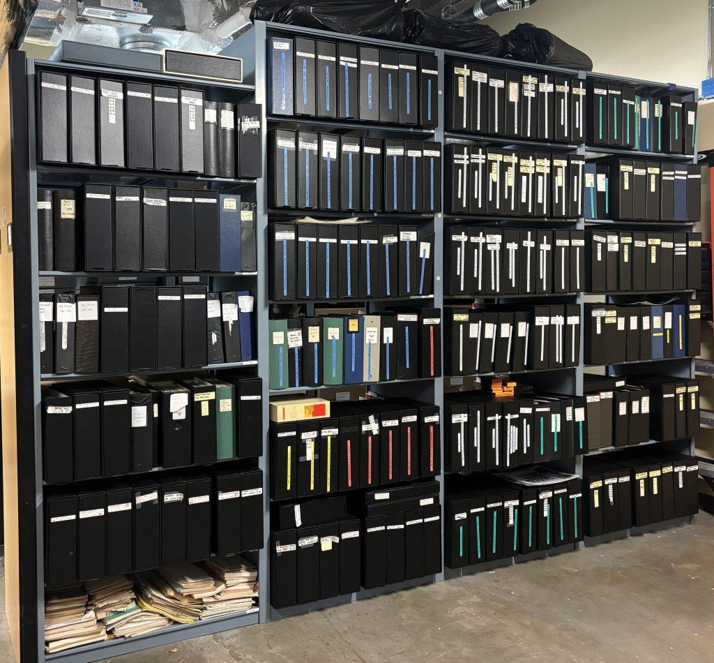 Eight foot high shelves by twelve foot wide shelves in the archives filled with black binders containing hundreds of photos of University of Texas athletes, teams, coaches, action, and staff.