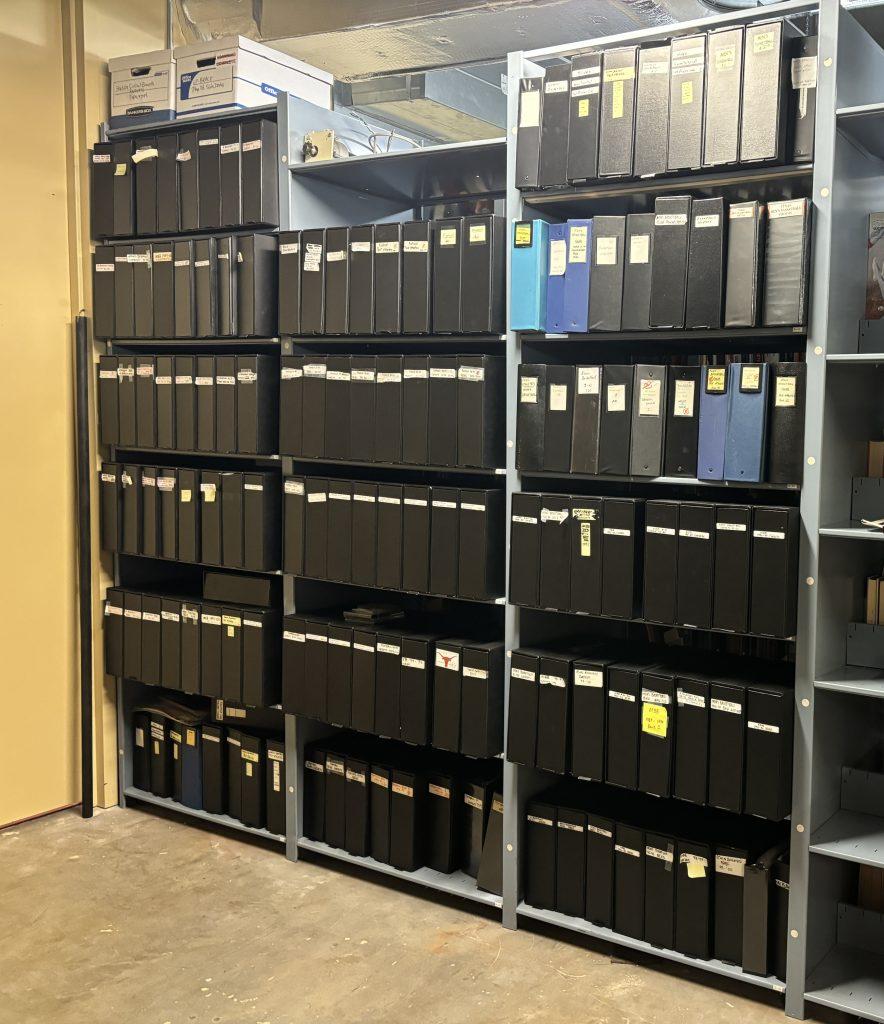 Eight foot high shelves by nine foot wide shelves in the archives filled with black binders containing hundreds of photos of University of Texas athletes, teams, coaches, action, and staff.