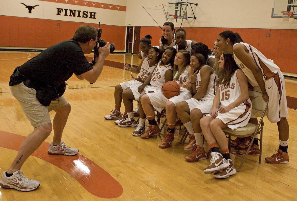 A color photo of Jim Sigmon shooting a photograph of the UT Women's Basketball team.