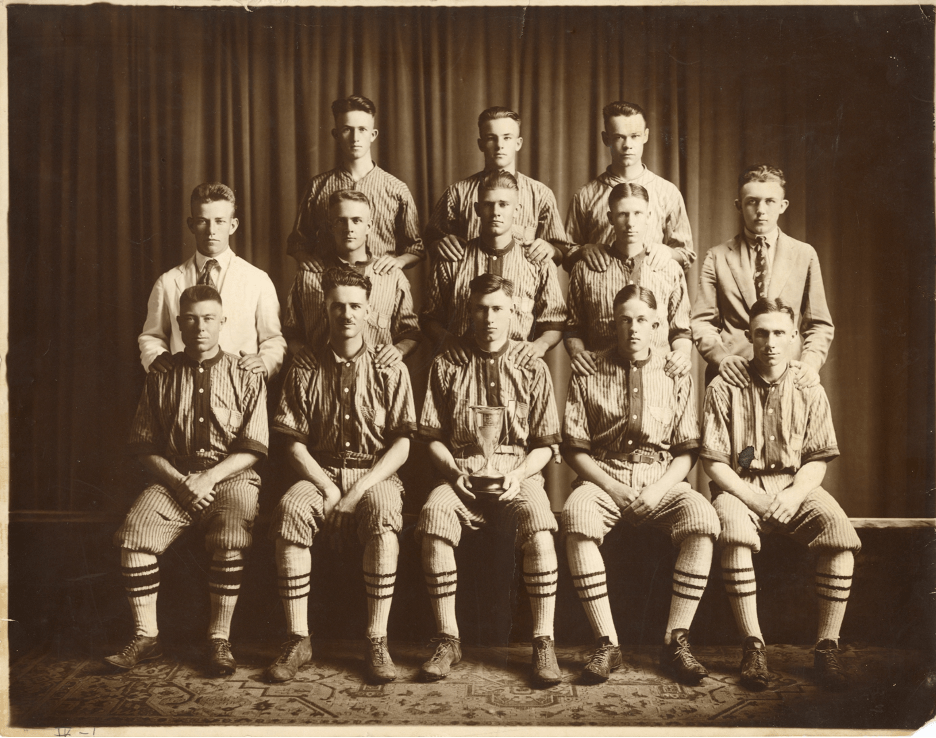 A black and white team photo of the 1920 intra-fraternity championship baseball team at the University of Texas. 11 players in uniform with 2 students in plain clothes as managers or coaches.