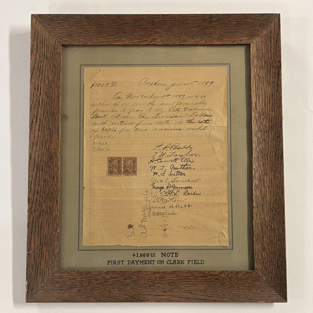 A color photo of a promissory note from 1899 framed in a brown wood frame.