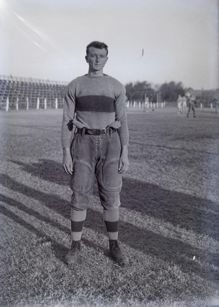 1914 image of football player Bert Walker in his uniform posing on the field.