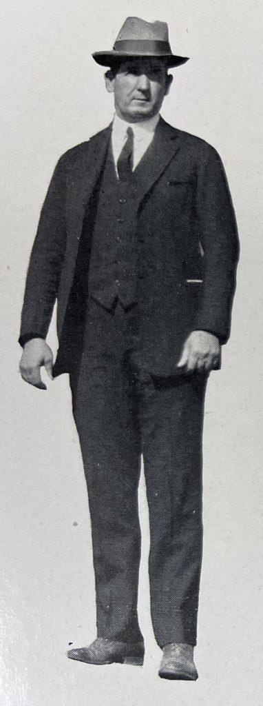 A black and white photograph of head football coach Doc Stewart, a white man in a three piece suit with hat on.