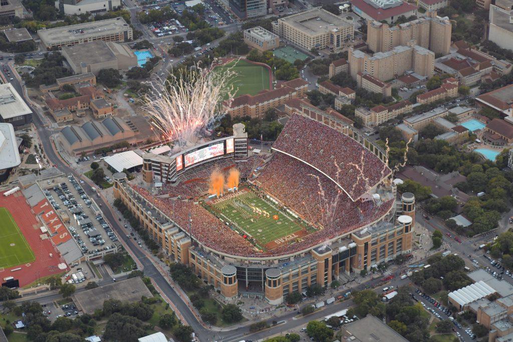 An aerial color photo of DKR Texas Memorial Stadium during the Texas v Georgia football game in 2024. Fireworks are going off at either end of the stadium.