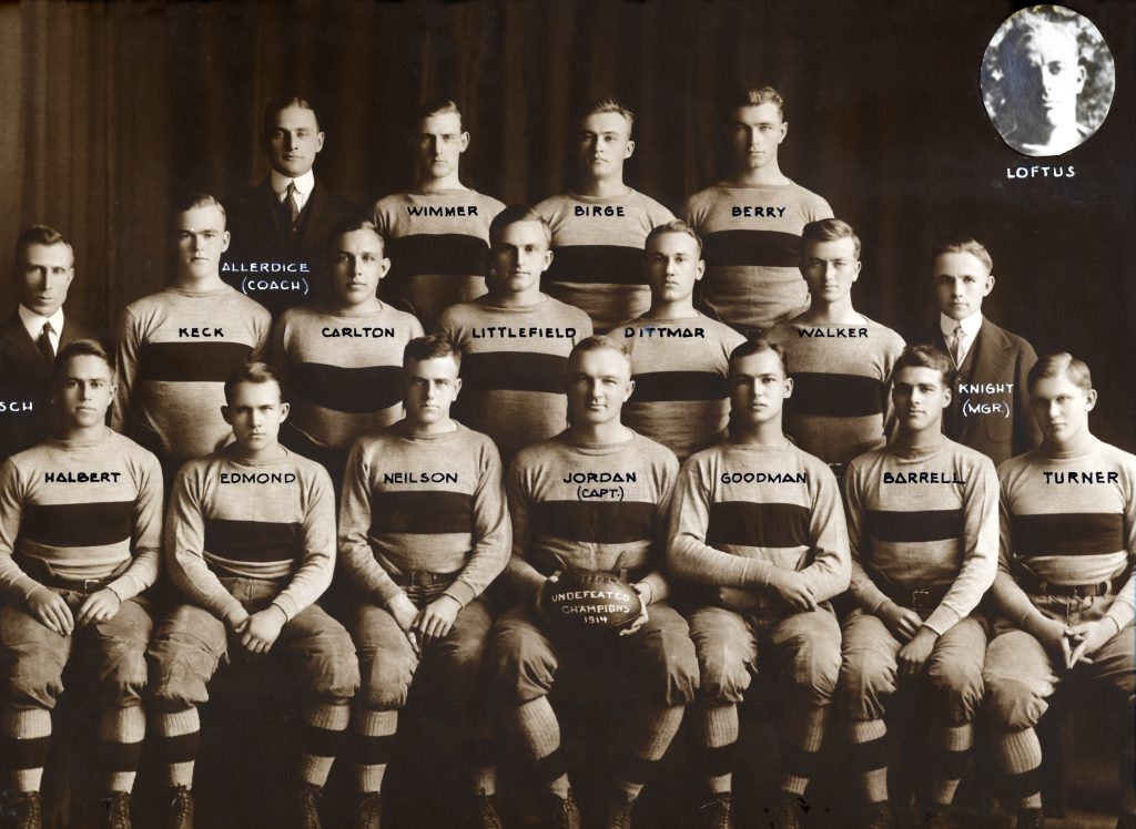 A black and white photo of male students seated in their football uniforms for the 1914 football season team picture.