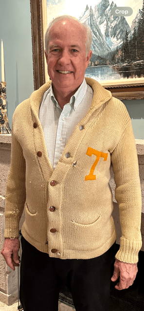 A White man in his late-60s to early-70s wearing a University of Texas letter sweater from 1914.