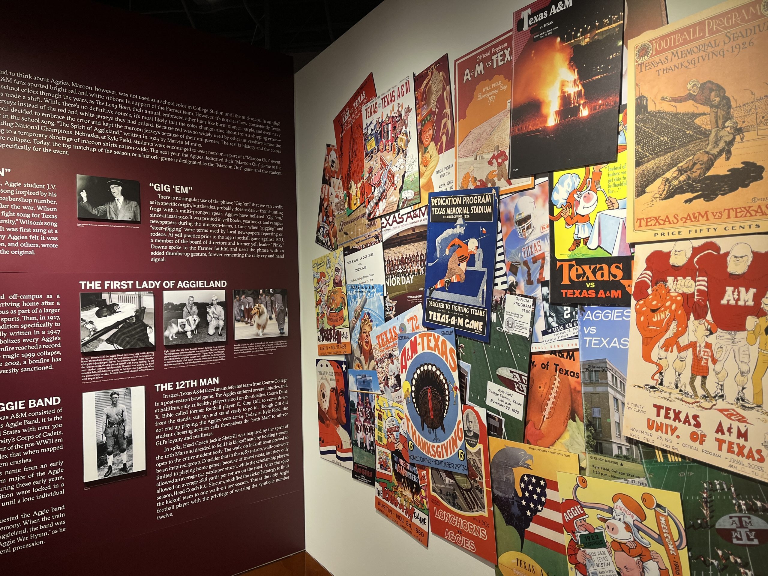A photo of a wall in the exhibit which features a vibrant collage of colorful game day programs, all from the Texas v A&M match up.