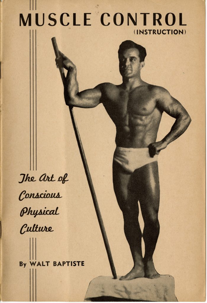 Walt Baptiste posing in white briefs holding a staff in his right hand vertically to the ground in black and white