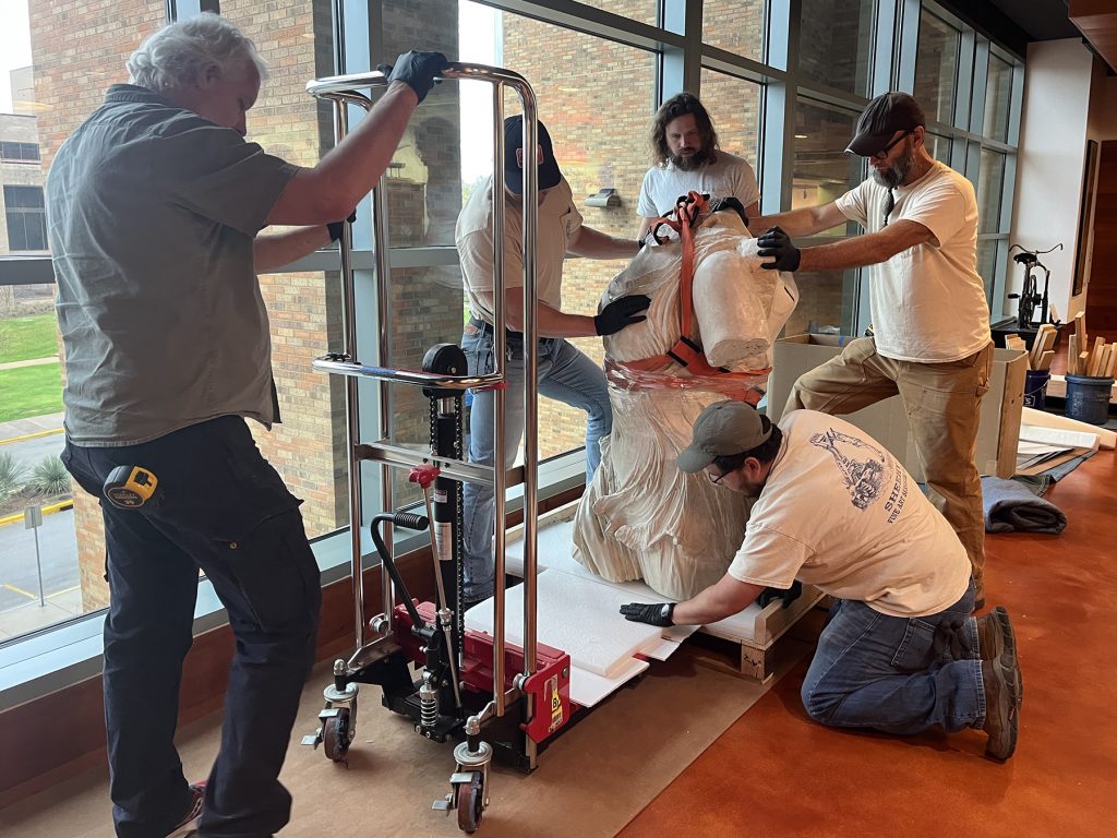 Sheehy Fine Art Services crew prepares to transition the top half of Winged Victory to a specialized dolly used in the process of assembly.