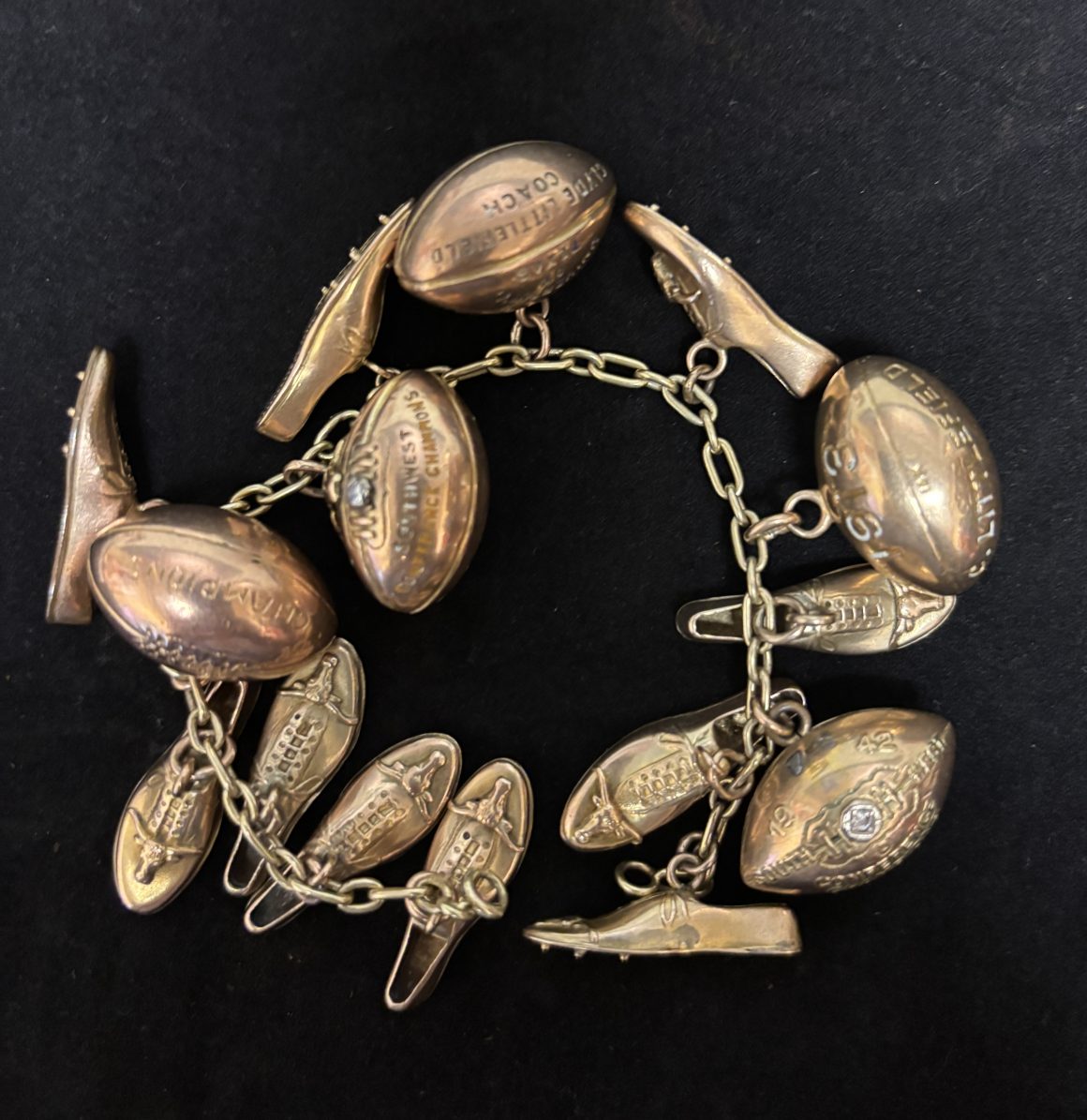 Clyde Littlefield's charm bracelet, adorned with Southwest Conference Championship charms, including footballs and track spikes.