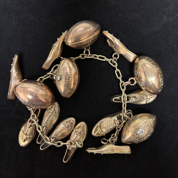Clyde Littlefield's charm bracelet, adorned with Southwest Conference Championship charms, including footballs and track spikes.
