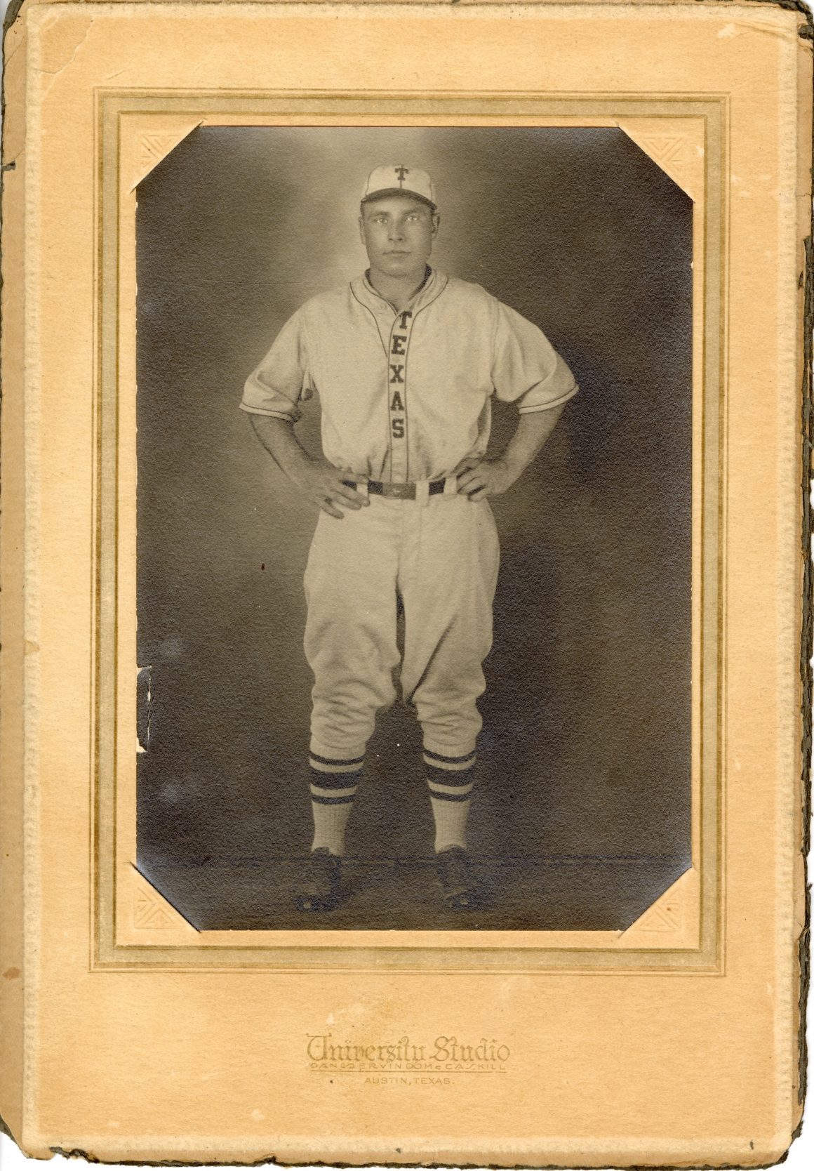 A photo of a man in a University of Texas varsity baseball uniform from 1928 secured in matting from University Studio