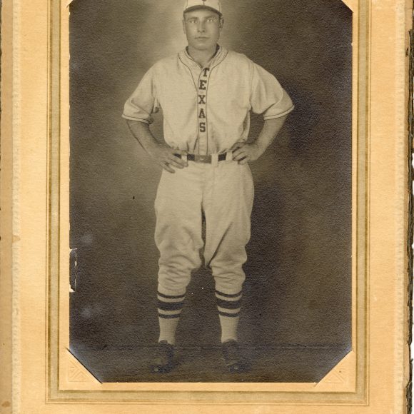 A photo of a man in a University of Texas varsity baseball uniform from 1928 secured in matting from University Studio